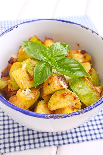 Gebratene Zucchini mit Knoblauch und Basilikum in der weißen Platte