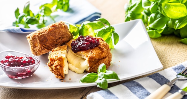 Gebratener Camembert oder Brie mit Preiselbeermarmelade und Basilikum.