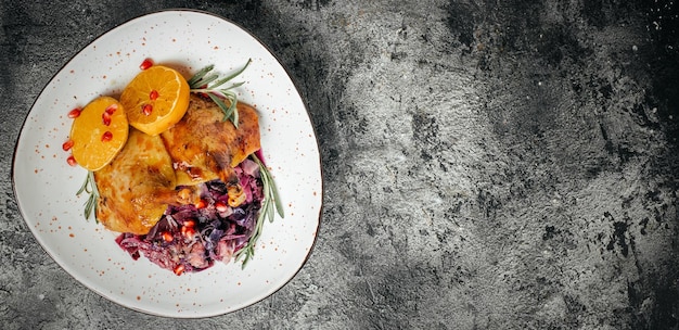 Gebratener Entenschenkel-Rotkohl auf dunklem Hintergrund Lange Banner-Format-Draufsicht