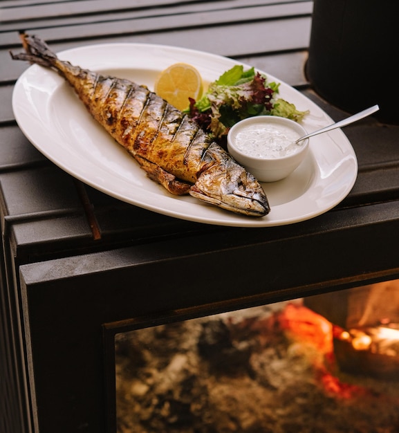 Gebratener Fisch mit Fischsauce schön auf einem Teller platziert