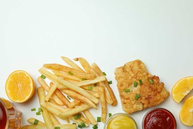 Gebratener Fisch mit Pommes Frites und Zitrone isoliert auf Weiß