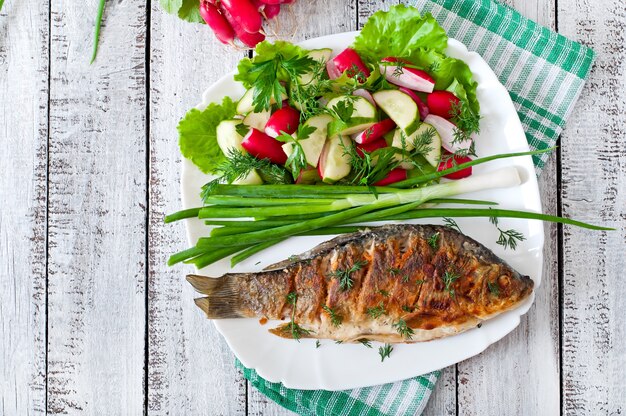 Foto gebratener fischkarpfen und frischgemüsesalat