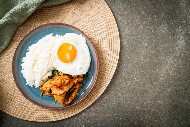 Gebratener gebratener Fisch mit Basilikum und Spiegelei auf Reis - asiatische Küche