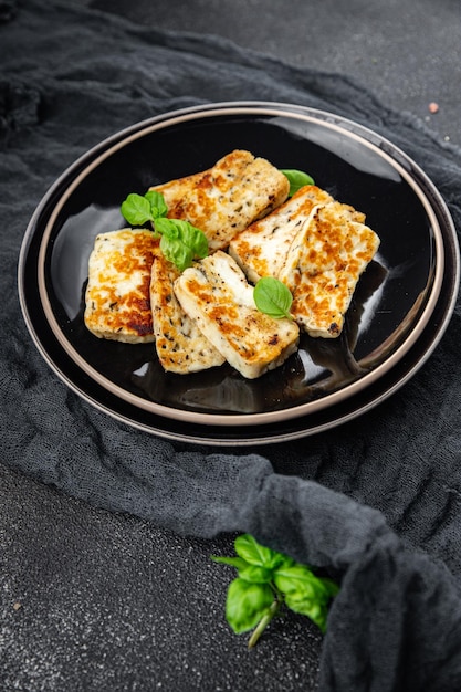 Gebratener Käse, Halloumi-Basilikum, Mahlzeit, Snack auf dem Tisch, Kopierraum, Lebensmittelhintergrund, rustikale Draufsicht