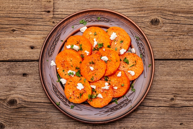 Gebratener Kürbis mit gesalzenem Käse und Kräutern