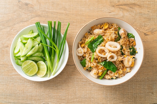 Gebratener Reis mit Tintenfisch oder Oktopus in Schüssel - gebratener Reis mit Tintenfisch, Ei und Grünkohl
