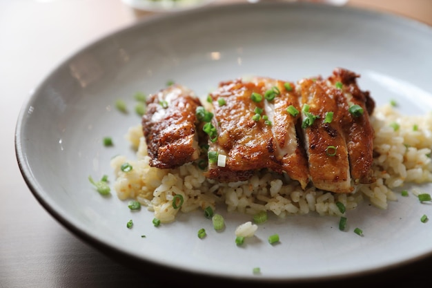 Foto gebratener reis nasi goreng mit hähnchen auf holzhintergrund