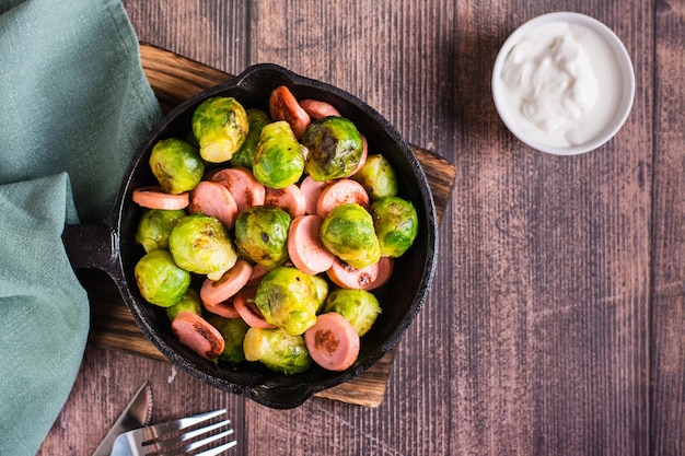 Gebratener Rosenkohl mit Würstchen in einer Bratpfanne auf dem Tisch Home Dinner Draufsicht