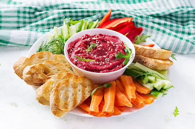 Gebratener Rübenhummus mit Toast und Gemüse. Rote-Bete-Hummus.