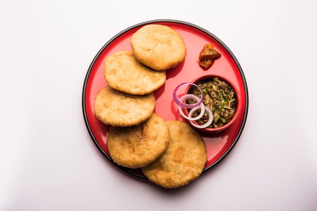 Gebratener Sattu Litti Chokha serviert mit Baingan Bharta, Zwiebeln und Essiggurke, beliebtes Rezept aus Bihar, Indien