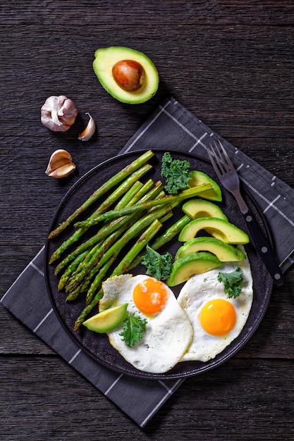 Foto gebratener spargel, reife avocado und spiegeleier