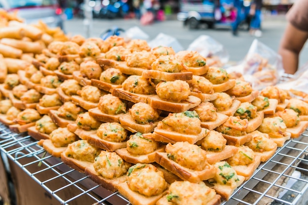 Gebratenes Brot mit gehacktem Schweinefleisch verbreitete für Verkauf an einem Markt in Bangkok, Thailand.