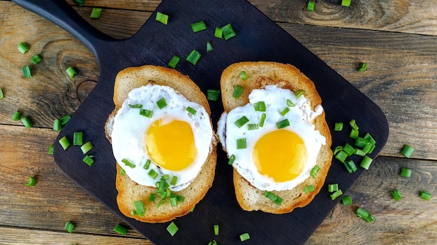 Foto gebratenes eier-sandwich mit eigelb und chili-pfeffer auf gerösteter brotscheibe mit grüner zwiebel