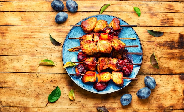 Gebratenes Fleisch gegrillt auf Holzspießen. Kebabs in Pflaumensauce. Rustikale Art