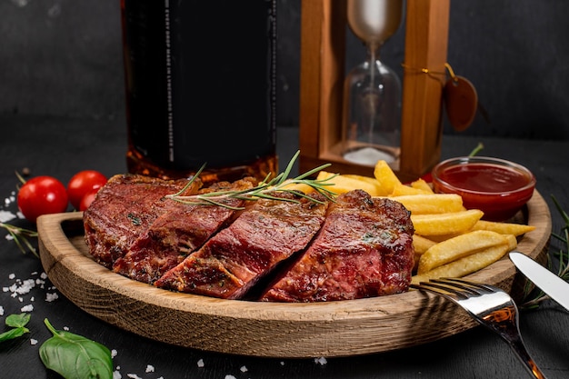 Gebratenes Fleischsteak mit Pommes Frites und Ketchup auf Holzhintergrund