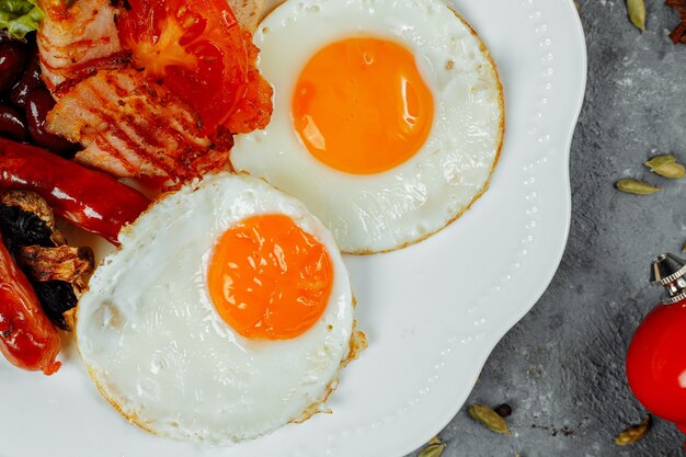 Gebratenes Frühstück mit Speck, Würstchen und gebackenen Bohnen.