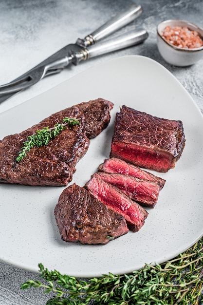 Foto gebratenes geschnittenes rumpffleischsteak auf einem teller mit thymian.