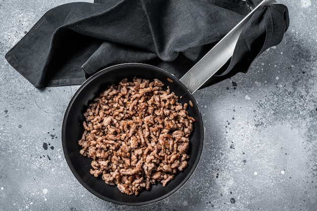 Gebratenes Hackfleisch zu italienischer Pasta Grauer Hintergrund Ansicht von oben