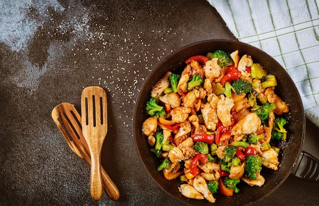 Gebratenes Hähnchen mit Brokkoli, Paprika auf dunkler Oberfläche