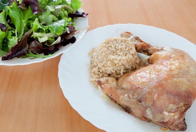 Gebratenes Hähnchen mit Reis und Salat.