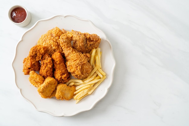 Gebratenes Hühnchen mit Pommes Frites und Nuggets auf dem Teller