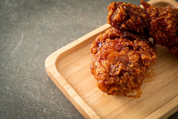 gebratenes Hühnerfleisch mit scharfer koreanischer Sauce auf Holzplatte