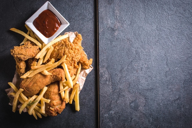 Gebratenes Hühnerfleisch und Pommes Frites aus dem freien Raum auf der rechten Seite