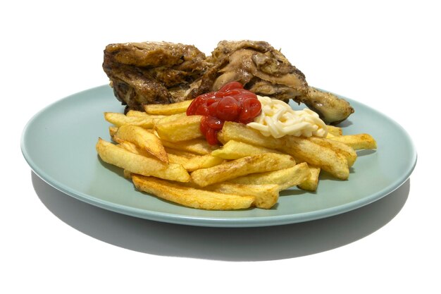 Foto gebratenes huhn mit pommes frites, mit ketchup und mayonnaise, serviert auf einem türkisfarbenen teller