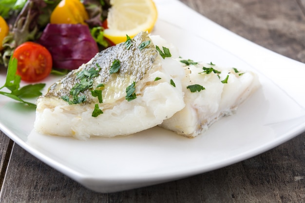 Foto gebratenes kabeljaufilet und salat in teller