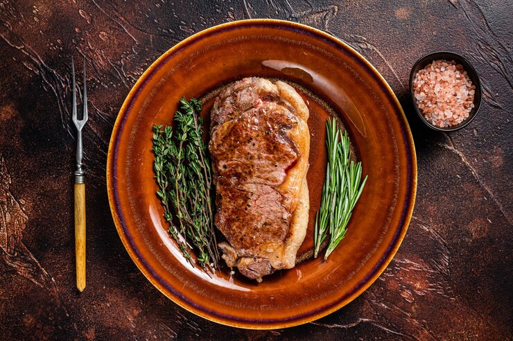 Foto gebratenes new york strip rinderfleischsteak oder streifenfilet in einem rustikalen teller
