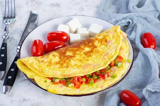 Gebratenes Omelett mit Rindfleisch, Tomaten, Zwiebeln und Kräutern. Leckeres Frühstück mit Rührei