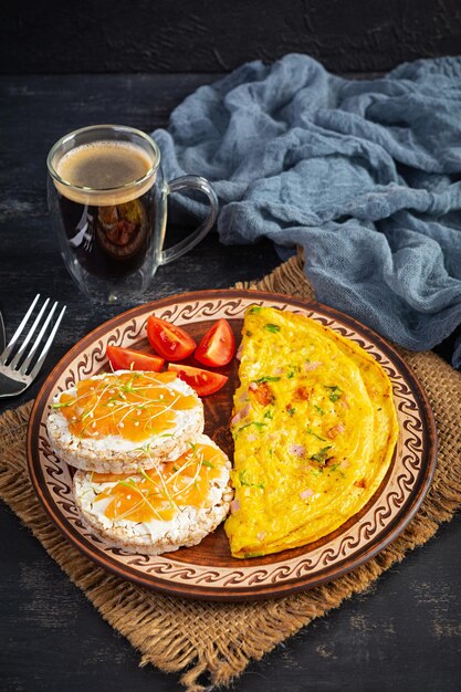 Gebratenes Omelett mit Rindfleisch und Kräutern. Leckeres Frühstück mit Eiern, Puffreiskuchen und Lachs