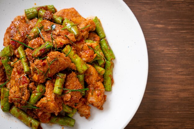 Gebratenes Schweinefleisch und rote Curry-Paste mit Bohnen verrühren