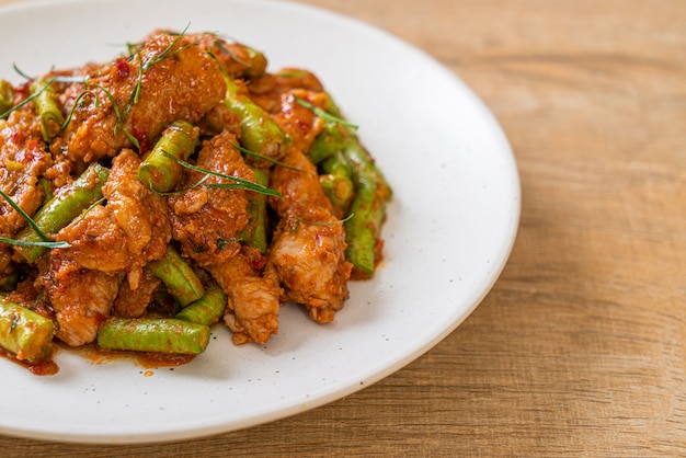 Gebratenes Schweinefleisch und rote Curry-Paste mit Stachelbohne nach asiatischer Art umrühren