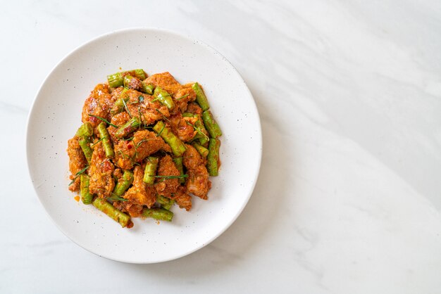 Gebratenes Schweinefleisch und rote Curry-Paste mit Stachelbohnen nach asiatischer Art umrühren