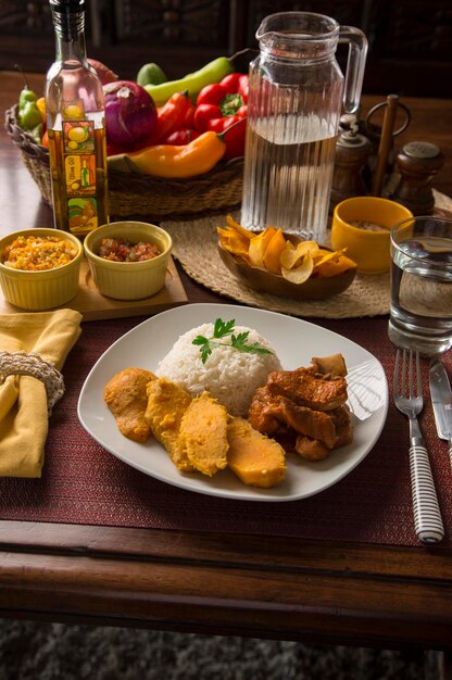 Gebratenes Schweinekotelett Süßkartoffelreis Peru traditionelle Hausmannskost mise en place Holztisch