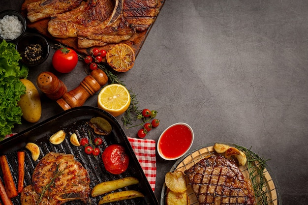 Gebratenes Schweinesteak auf der dunklen Oberfläche.