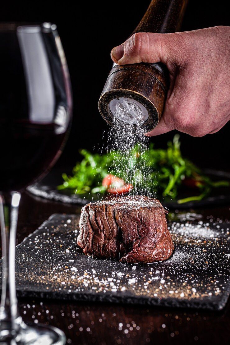 Gebratenes Schweinesteak auf einem schwarzen Teller