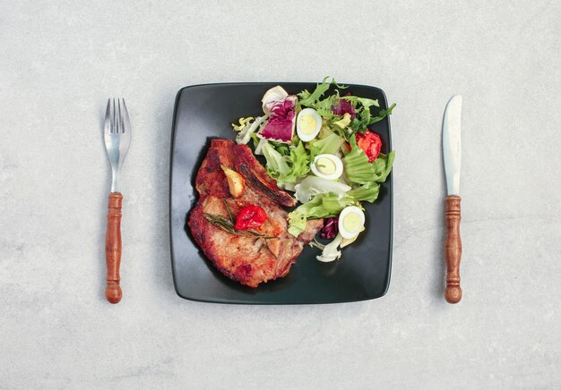 Gebratenes Schweinesteak mit frischem Gemüsesalat