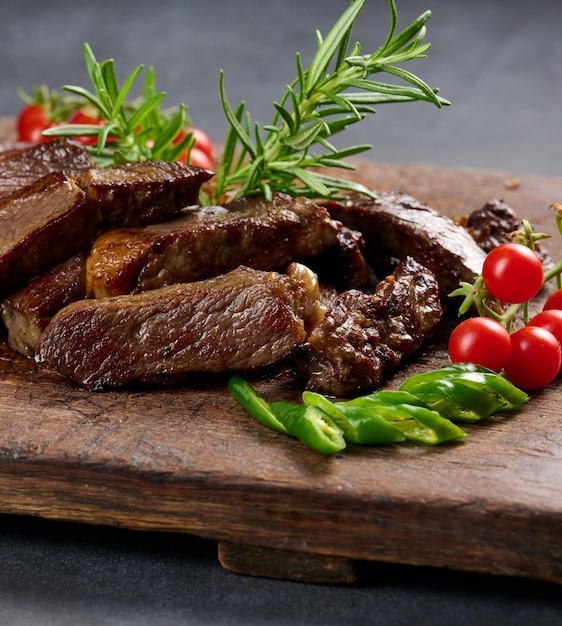 Gebratenes Stück Rindfleisch Ribeye in Stücke geschnitten auf einem Vintage-braunen Schneidebrett Gut gemacht Appetitliches Steak