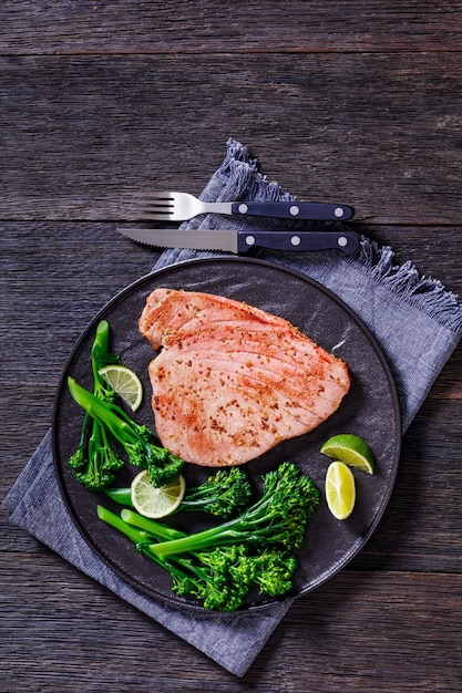 Foto gebratenes thunfischsteak mit gekochtem broccolini und limette