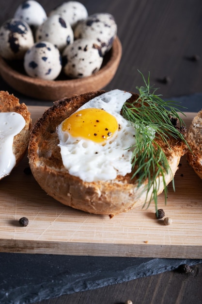 Gebratenes Wachtelei in einem runden Brötchen mit Dill gebacken