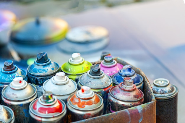 Gebrauchte Aerosol-Sprühfarbe in Dosen im Karton.