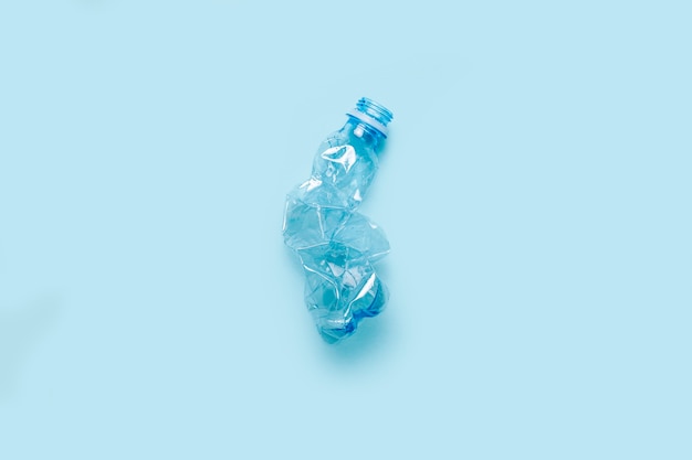 Gebrauchte Plastikflasche auf blauem Hintergrund. Das Konzept der Verwendung von Kunststoff. Umweltproblem, globale Umwelt. Ansicht von oben, flach.