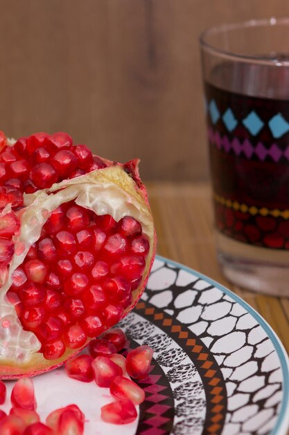 Gebrochener roter und saftiger Granatapfel frisch gepresster Saft in einem Glas