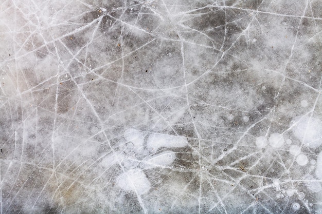 Gebrochenes Eis auf gefrorener Pfütze im Winter