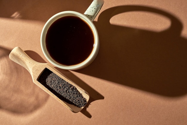 Gebrühter Tee in einer Tasse auf braunem Hintergrund. Türkischer Tee in einem Holzlöffel