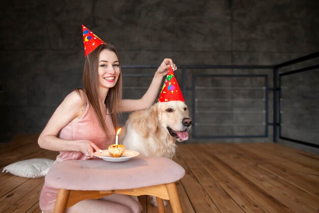 Geburtstag des Hundes Ein junges Mädchen feiert den Geburtstag des Hundes und umarmt ihn zu Hause