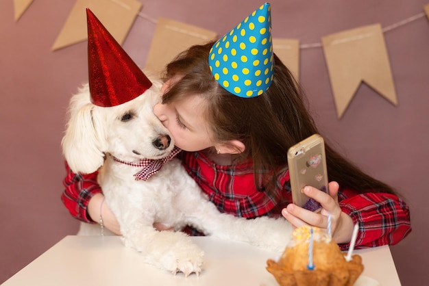 Geburtstag eines Hundes und eines Kindes eine Party für einen Hund mit Hut und setzte sich ans Telefon