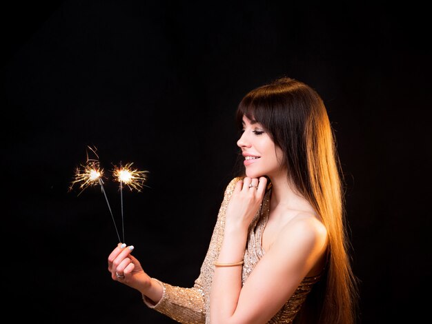 Geburtstag oder Silvesterparty junge schöne Brünette in einem goldenen Kleid